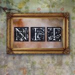 Ornate gold frame with the letters 'NFT' in black and white against a vintage wall.